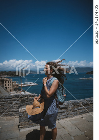 Woman Enjoying Coastal View with Wind Blowing Hair 141174705