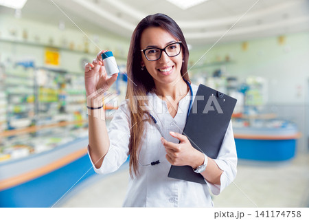 Pharmacist showing medication 141174758