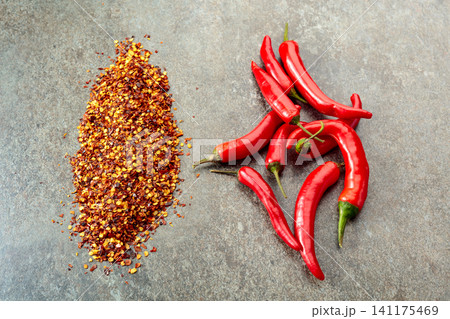Red hot chili peppers on a stone background. Red hot chili peppers on a stone background. 141175469