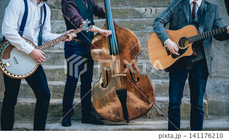 Trio of musicians with a guitar, banjo and contrabass 141176210