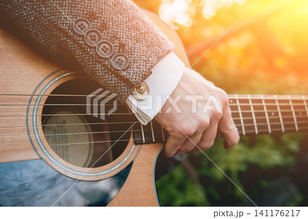 Man's hands playing acoustic guitar. Background Man's hands playing acoustic guitar. Background 141176217