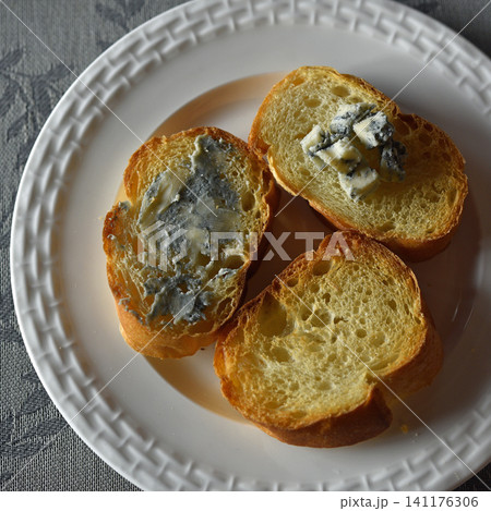 Blue cheese on baguette on white plate. 141176306