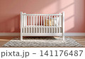 White baby crib standing in bright nursery 141176487