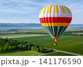 Colorful hot air balloon flying over green vineyards 141176590