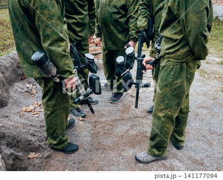Men with guns playing at paintball. Outdoors Men with guns playing at paintball. Outdoors 141177094