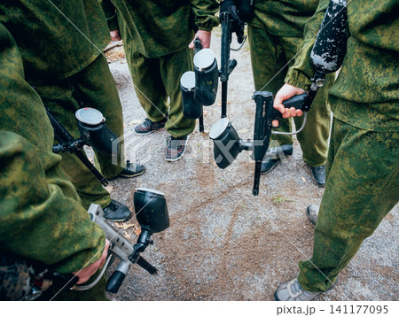 Men with guns playing at paintball. Outdoors 141177095