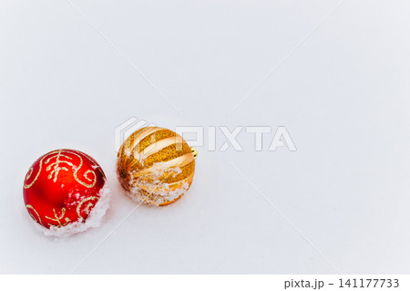 Red and gold Christmas baubles with snow isolated on a white background. Holiday decoration for Christmas celebration, seasonal greeting cards and winter product design. Red and gold Christmas baubles with snow isolated on a white background. Holiday decoration for Christmas celebration, seasonal greeting cards and winter product design. 141177733