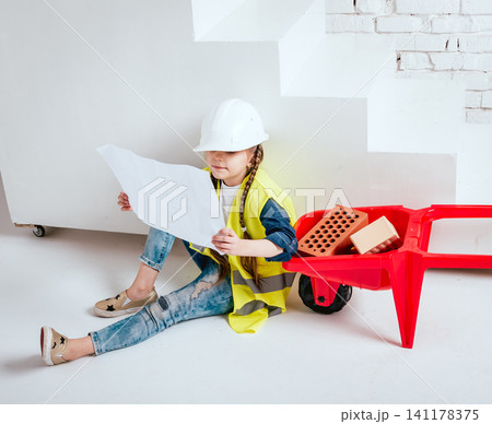 Little girl with wheelbarrow on the white background. Construction Little girl with wheelbarrow on the white background. Construction 141178375