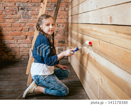 Little girl in a room with a wooden wall. Construction Little girl in a room with a wooden wall. Construction 141178380