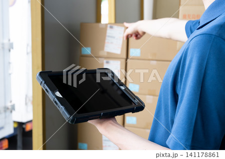 倉庫でタブレットを使う男性の手元 倉庫でタブレットを使う男性の手元 141178861