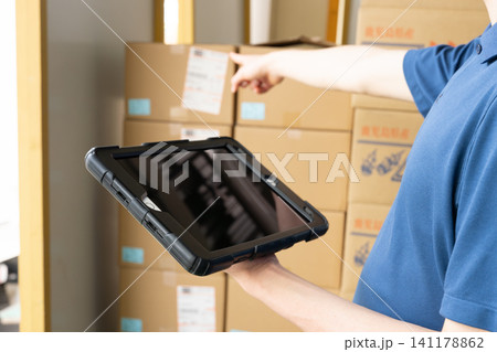 倉庫でタブレットを使う男性の手元 倉庫でタブレットを使う男性の手元 141178862
