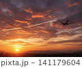 夕焼け空に飛ぶ飛行機 141179604