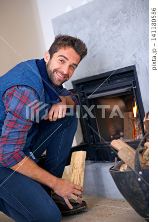 Fireplace, happy and portrait of man in home with fire for heat, warmth and light in winter. Flame, hearth and person with firewood, log and wood for comfort, cozy and relaxing house in living room Fireplace, happy and portrait of man in home with fire for heat, warmth and light in winter. Flame, hearth and person with firewood, log and wood for comfort, cozy and relaxing house in living room 141180586
