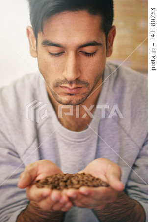 Man, holding coffee beans and production with smell, thinking and organic grain for export at warehouse. Person, employee and crop for manufacturing, industry and factory for aroma test in Colombia 141180783