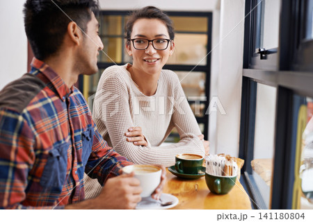 Happy couple, window and relax with coffee at cafe for chatting, talking or social bonding. Young man and woman with smile for conversation, beverage or morning drink at indoor restaurant together 141180804