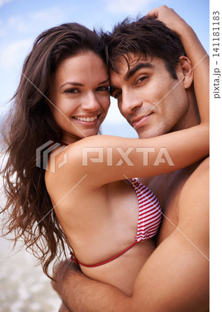 Hug, smile and portrait of couple by beach on vacation, adventure or holiday for romantic travel. Happy, love and young man and woman embracing by ocean for tropical outdoor anniversary weekend trip. Hug, smile and portrait of couple by beach on vacation, adventure or holiday for romantic travel. Happy, love and young man and woman embracing by ocean for tropical outdoor anniversary weekend trip. 141181183