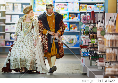 Supermarket, royal man and woman with costume for food choice, grocery shopping or product. Convenience store, king and queen in victorian outfit for purchase, selection or price check from customer Supermarket, royal man and woman with costume for food choice, grocery shopping or product. Convenience store, king and queen in victorian outfit for purchase, selection or price check from customer 141181327