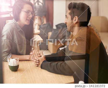 Happy couple, relax and talking with date at cafe for conversation or enjoying romance at indoor restaurant. Young man and woman by window at coffee shop for social, chatting or bonding together Happy couple, relax and talking with date at cafe for conversation or enjoying romance at indoor restaurant. Young man and woman by window at coffee shop for social, chatting or bonding together 141181372