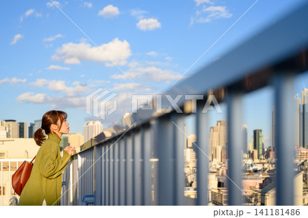 都会の空を見上げる女性 141181486
