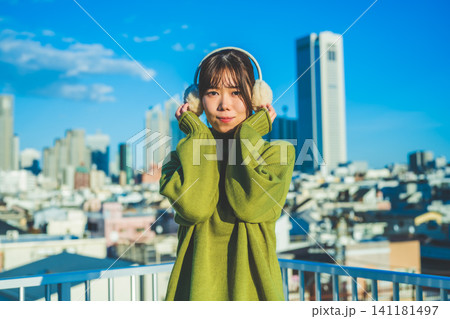 青空の下、耳当てをした笑顔の女性 青空の下、耳当てをした笑顔の女性 141181497