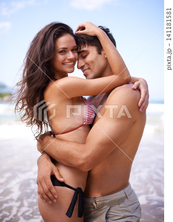 Love, hug and portrait of happy couple at ocean for tropical holiday adventure, relax and bonding together. Nature, man and woman smile on romantic date with beach, blue sky and embrace on vacation. Love, hug and portrait of happy couple at ocean for tropical holiday adventure, relax and bonding together. Nature, man and woman smile on romantic date with beach, blue sky and embrace on vacation. 141181581