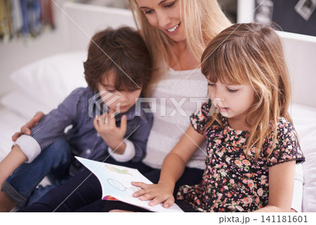 Reading, mother and children on couch with storytelling for bonding, teaching and learning together in home. Woman, son and daughter relax on sofa with book, smile and happy family in living room 141181601