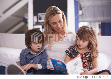 Reading, mother and children on couch with book for bonding, teaching and learning together in home. Woman, son and daughter relax on sofa with storytelling, smile and happy family in living room 141181602