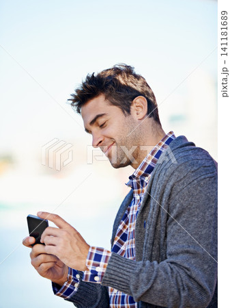 Man, cellphone and texting at harbor on mobile network by sea for typing, smile and reading outdoor. Person, phone and click at urban port in city for notification, app or social media in Cape Town 141181689