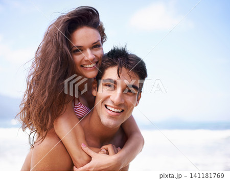 Piggyback, ocean and portrait of couple at beach on vacation, adventure or holiday for romantic travel. Happy, love and young man and woman on date by sea for tropical anniversary weekend trip. Piggyback, ocean and portrait of couple at beach on vacation, adventure or holiday for romantic travel. Happy, love and young man and woman on date by sea for tropical anniversary weekend trip. 141181769