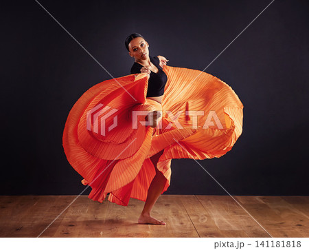 Dancer, performance and woman in studio for creative, movement and rhythm on floor. African person isolated in dress for art deco and stretch body for theater, ballet or jazz on dark background Dancer, performance and woman in studio for creative, movement and rhythm on floor. African person isolated in dress for art deco and stretch body for theater, ballet or jazz on dark background 141181818