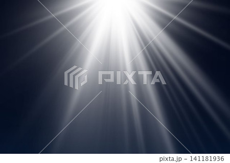Bright light rays shining from above creating an abstract lens flare effect on a dark background 141181936