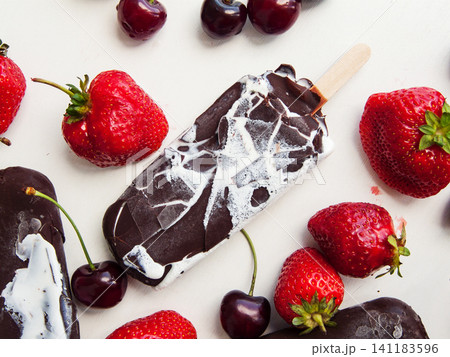 Sweet chocolate vanilla ice cream with red ripe strawberries and cherries, summer refreshing dessert 141183596