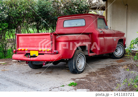 old red pickup truck with an open body in the village 141183721