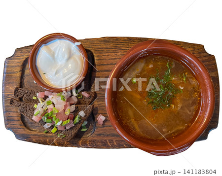 Traditional Ukrainian borscht beet soup served in a clay bowl with sour cream lard and dark rye bread on a wooden board Traditional Ukrainian borscht beet soup served in a clay bowl with sour cream lard and dark rye bread on a wooden board 141183804