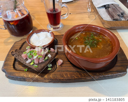 Traditional Ukrainian borscht beet soup served in a clay bowl with sour cream lard and dark rye bread on a wooden board Traditional Ukrainian borscht beet soup served in a clay bowl with sour cream lard and dark rye bread on a wooden board 141183805