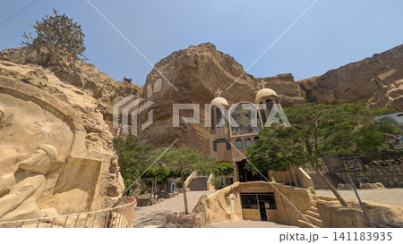 Facade of the entrance of a cave church surrounded by religious design carved rocky cliff Facade of the entrance of a cave church surrounded by religious design carved rocky cliff 141183935