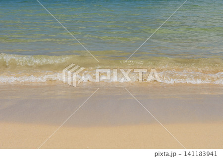 透明度の高いエメラルドグリーンの海と白い波が寄せる美しい砂浜の背景 透明度の高いエメラルドグリーンの海と白い波が寄せる美しい砂浜の背景 141183941