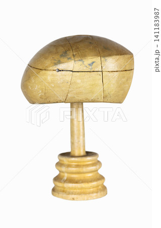Antique millinery form for shaping berets and hats on a stand. Vintage wooden block. Craftsmanship, old professions, artisan work concept. Isolated on white background. Copy space Antique millinery form for shaping berets and hats on a stand. Vintage wooden block. Craftsmanship, old professions, artisan work concept. Isolated on white background. Copy space 141183987