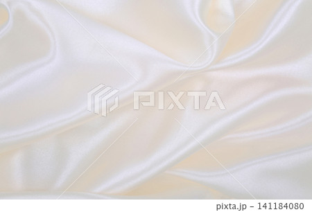 Smooth elegant white silk or satin luxury cloth texture as wedding background. Luxurious background design Smooth elegant white silk or satin luxury cloth texture as wedding background. Luxurious background design 141184080