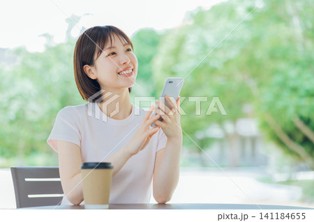 スマホを持つショートヘアの若い女性 スマホを持つショートヘアの若い女性 141184655