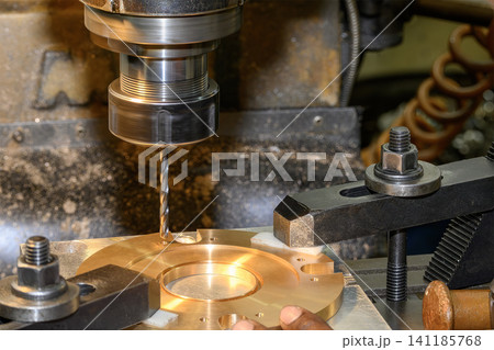 High-precision hole making process on a brass material part using a drill tool on a milling machine. 141185768