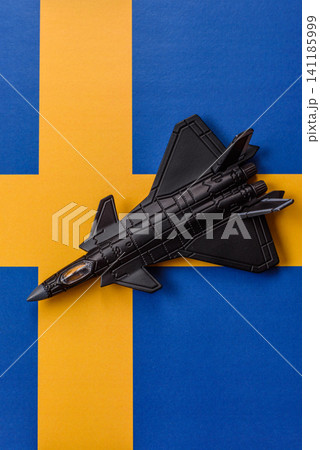 A fighter jet against the Swedish flag as a conceptual background representing defense A fighter jet against the Swedish flag as a conceptual background representing defense 141185999