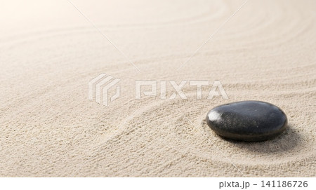 A black stone on a sandy beach 141186726