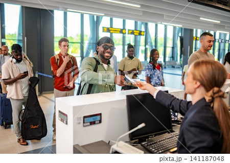 Smiling man checking in at airport with travel agent 141187048