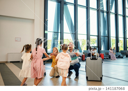 Family reunion at airport terminal welcoming children Family reunion at airport terminal welcoming children 141187068