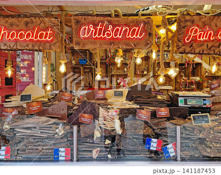 Paris, France - December 10, 2025: rustic vendor stall showcases large slabs of artisanal French chocolate in dark, milk, and white varieties. Festive holiday display at the Tuileries Christmas Market 141187453