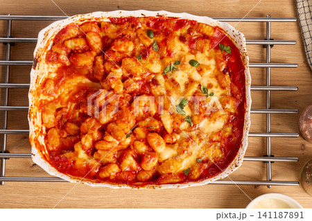 Baked gnocchi with tomato sauce, melted cheese and basil in ceramic dish viewed from above Baked gnocchi with tomato sauce, melted cheese and basil in ceramic dish viewed from above 141187891