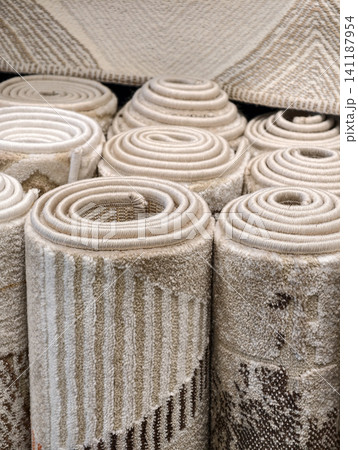 Soft residential carpets in warm tones rolled into rolls in a supermarket presenting attractive home flooring inspiration Soft residential carpets in warm tones rolled into rolls in a supermarket presenting attractive home flooring inspiration 141187954