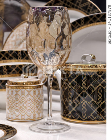 High end glass highlighted on a luxurious table setting with premium dining decor and elegant tableware behind High end glass highlighted on a luxurious table setting with premium dining decor and elegant tableware behind 141187979