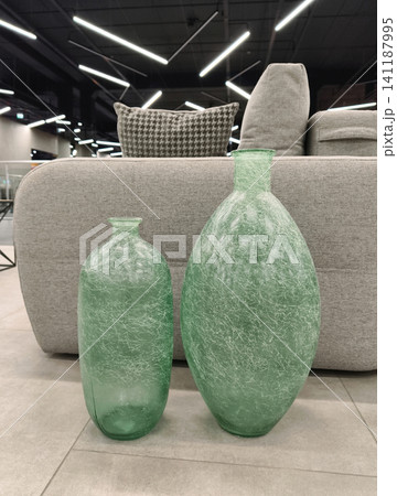 Green decorative glass vases featured in a furniture showroom, combining elegant form and rich color to complement stylish home decor arrangements Green decorative glass vases featured in a furniture showroom, combining elegant form and rich color to complement stylish home decor arrangements 141187995